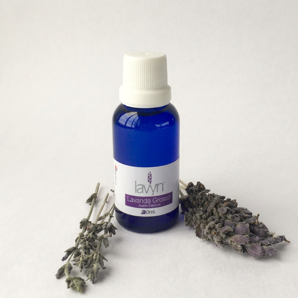 Aceite esencial de lavanda Grosso Lavyn de 30 ml con ramas de lavanda sobre fondo claro
